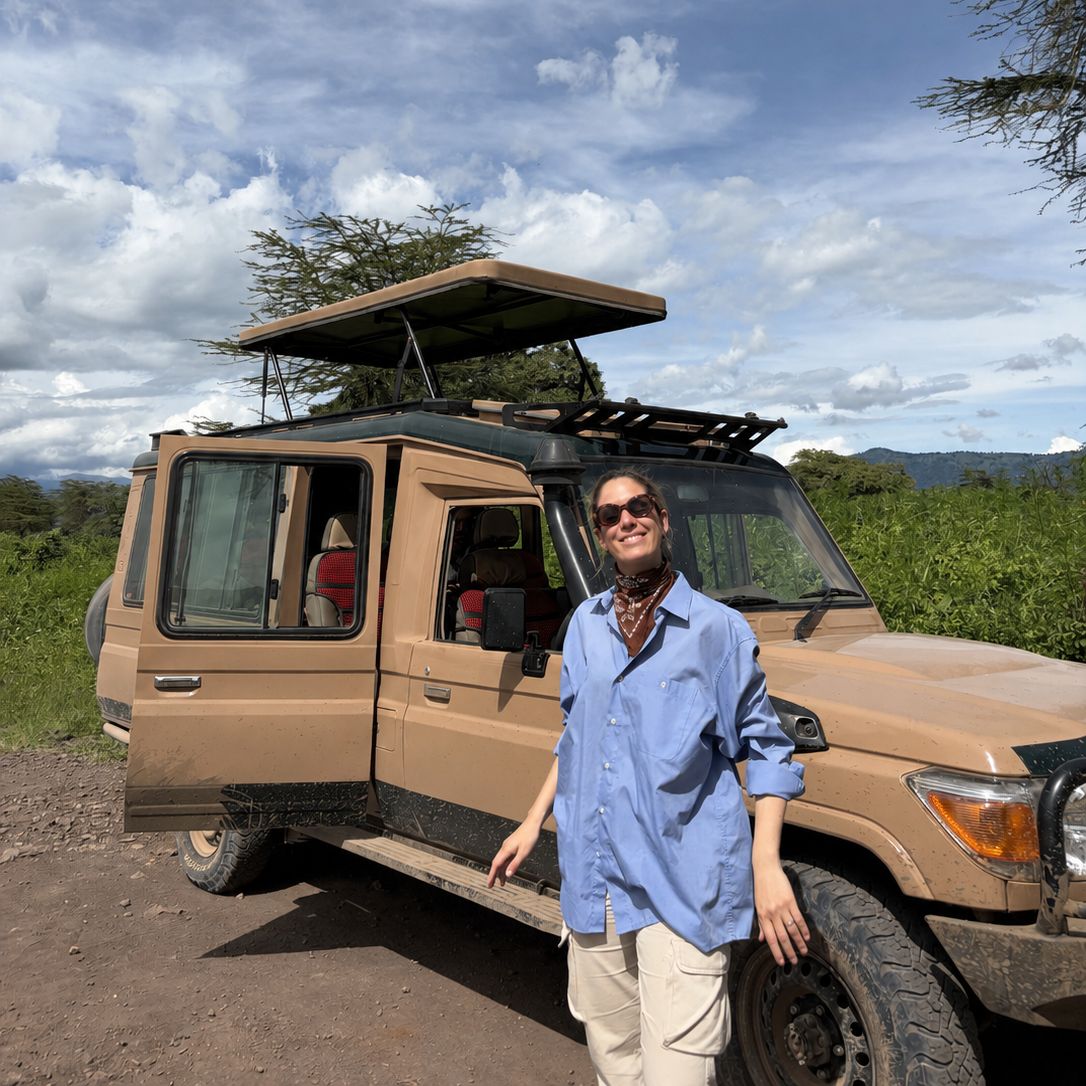 Viajera junto a un jeep de safari en Tanzania